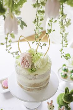 there is a cake with flowers on the top and decorations around it, along with other small figurines