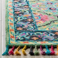 a multicolored rug with tassels on the floor