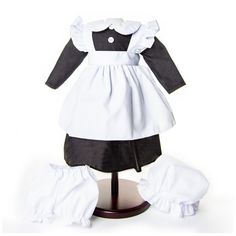 a white and black dress on a wooden stand with clothes underneath the mannequin