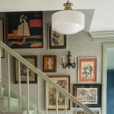 a staircase with pictures on the wall and a chandelier hanging from the ceiling