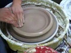 a person is making a bowl out of clay