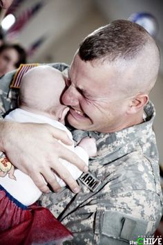 a soldier holding a baby in his arms