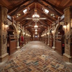 the inside of a building with stone flooring and wooden beams, chandeliers hanging from the ceiling