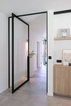 an open door leading to a hallway with a potted plant on the sideboard