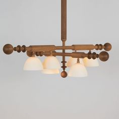 a wooden chandelier with five lights hanging from it's sides and four white glass shades on each light fixture