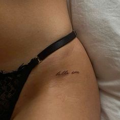 a woman's stomach with the word love tattooed on her lower side ribcage