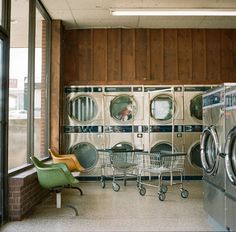 a laundry room with washing machines and chairs