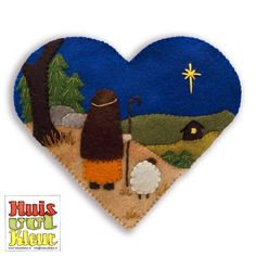 a felt heart with an image of a shepherd and sheep