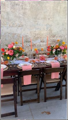 the table is set with pink napkins and place settings for two people to eat