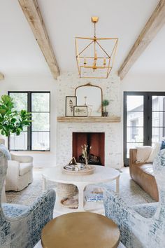 a living room with couches, chairs and a fire place in the middle of it