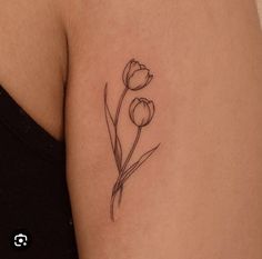 a small flower tattoo on the back of a woman's left arm