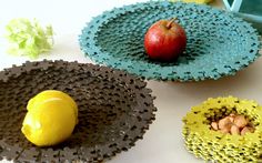 three bowls with fruit in them sitting on a white table next to a yellow apple