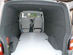 the back end of a van with its cargo door open and seats folded up in place