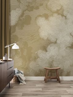 a room with a chair, lamp and wallpaper on the walls that has clouds painted on it