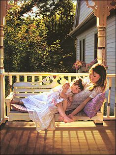 two women sitting on a porch swing with one holding a baby and the other laying down