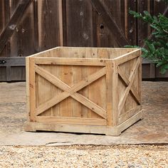 a wooden planter sitting on the ground next to a fence