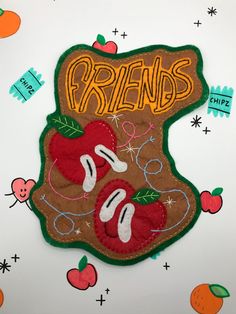 a close up of a patch on a wall with fruit and writing that reads friends