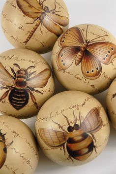 six painted eggs with bees and writing on them