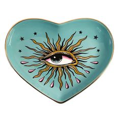 a heart shaped plate with an eye and stars painted on the side, in blue