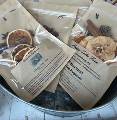 several bags of dried fruit sitting in a trash can filled with paper and cinnamons