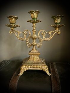 a golden candelabra sitting on top of a suitcase