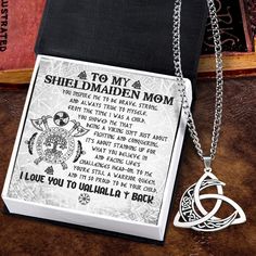 a book with a chain attached to it and a pendant on the cover that says, to my shield maiden mum