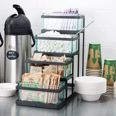 there is a coffee maker and cups on the counter