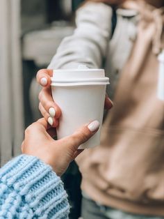 a woman holding a coffee cup in her hand