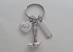 a silver keychain with a heart and a wrench on it that says dad