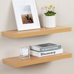 two wooden shelves with books and vases on them, one has a photo frame