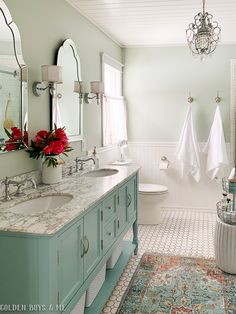 a bathroom with green cabinets and white walls