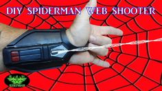 a spiderman web shooter is on the wrist of a man with his thumb up