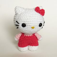 a crocheted hello kitty doll with a red dress