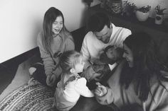 a group of people sitting on top of a bed with a baby in their lap