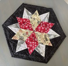 a black and red quilted table topper with white stars on the center piece