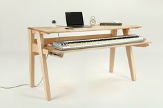 an electronic keyboard sitting on top of a wooden desk