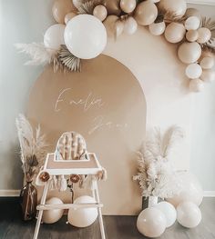 a baby's first birthday party with balloons and decorations on the wall behind it