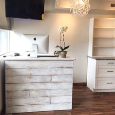 an empty kitchen with white cabinets and wood flooring is pictured in this image, there is a chandelier hanging from the ceiling