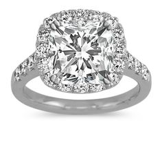 a cushion cut diamond surrounded by halos and pave set diamonds in 18k white gold