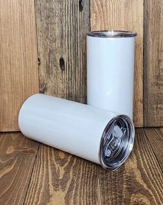 two white coffee mugs sitting on top of a wooden floor