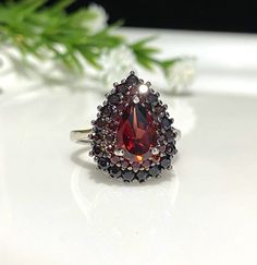 Vintage Sterling Silver Natural Dark Red Garnet Ring....Marked 925... Size 6...Total of weights 4.2grams...Measure of Face 17.6MM...It's in very good condition. Red Teardrop Ruby Rings, Hallmarked Red Cluster Ring, Red Hallmarked Cluster Ring In Fine Jewelry Style, Classic Pear-shaped Red Rings, Classic Red Pear-shaped Rings, Formal Red Garnet Cluster Ring, Red Pear-shaped Ring For Formal Occasions, Pear-shaped Red Rings For Formal Occasions, Red Ruby Pear-shaped Rings