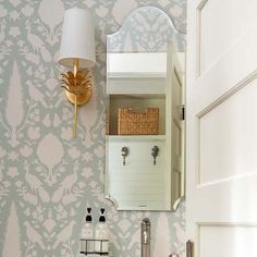 a white sink sitting under a bathroom mirror next to a wall mounted faucet