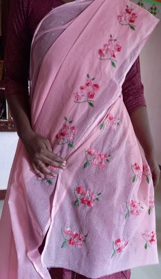 a woman wearing a pink sari with flowers on it