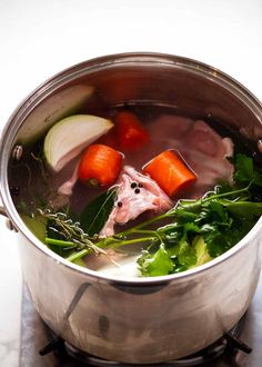 a pot filled with soup and vegetables on top of a stove