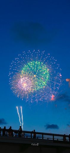 fireworks are lit up in the sky above a bridge