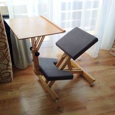 a folding table and chair sit in front of a window with curtains on the windowsill