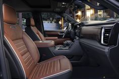 the interior of a luxury vehicle with tan leather seats and black trim, in front of a house