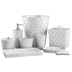 a white bathroom set with soap dispenser, toothbrush holder and other items