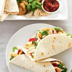 two white plates topped with tacos and salad