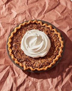 a pie topped with whipped cream on top of a table